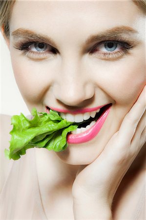 Young woman biting lettuce Foto de stock - Royalty Free Premium, Número: 614-06116224