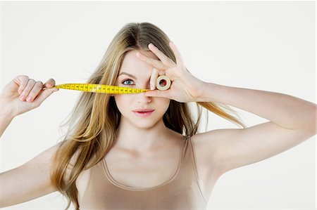 Young woman holding tape measure Stock Photo - Premium Royalty-Free, Code: 614-06116227