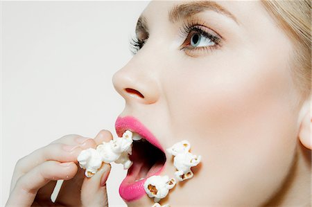 eat mouth closeup - Jeune femme mangeant maïs soufflé Photographie de stock - Premium Libres de Droits, Code: 614-06116228