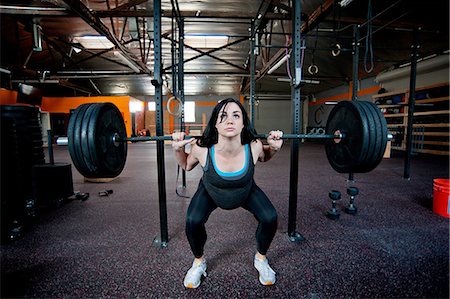 squats workout - Pregnant young woman weight lifting with barbell Stock Photo - Premium Royalty-Free, Code: 614-06116368