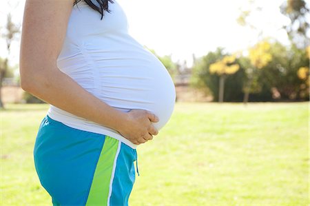 Enceinte jeune femme touchant l'estomac, vue latérale Photographie de stock - Premium Libres de Droits, Code: 614-06116374