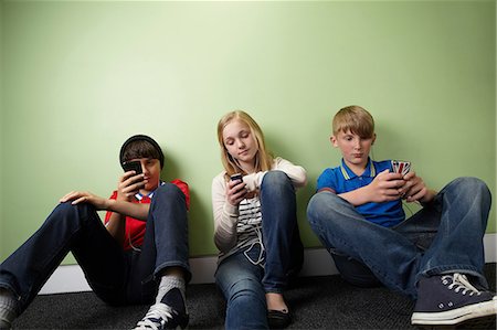 Three friends with mp3 players Stock Photo - Premium Royalty-Free, Code: 614-06116440