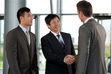 Multiracial businessmen shaking hands Stock Photo - Premium Royalty-Free, Code: 614-06116471