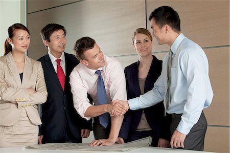 simsearch:614-06116477,k - Multi racial businesspeople shaking hands over blueprint Stock Photo - Premium Royalty-Free, Code: 614-06116534