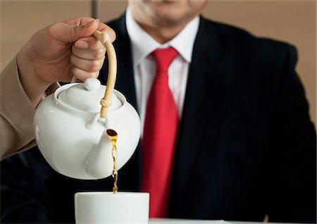 Woman pouring tea for businessman Foto de stock - Sin royalties Premium, Código: 614-06116531