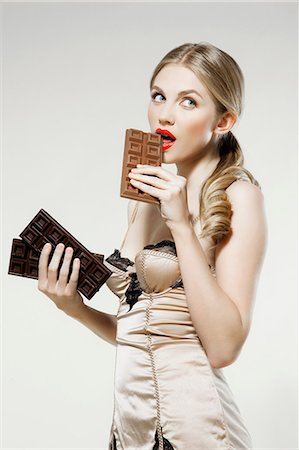 simsearch:614-06116197,k - Young woman biting chocolate Stock Photo - Premium Royalty-Free, Code: 614-06168625