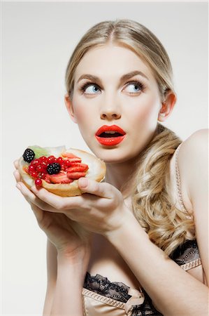 satisfied sexually - Young woman holding fresh fruit tart Stock Photo - Premium Royalty-Free, Code: 614-06168621
