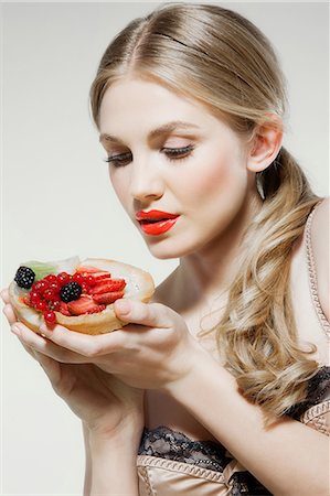 people eating desserts - Young woman holding fresh fruit tart Stock Photo - Premium Royalty-Free, Code: 614-06168634