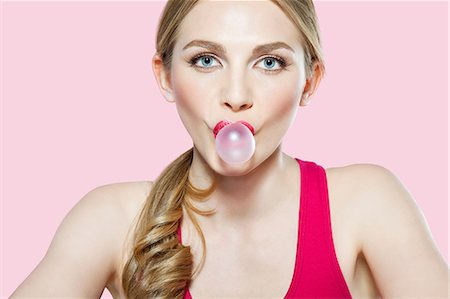 Jeune femme soufflant de bubble-gum Photographie de stock - Premium Libres de Droits, Code: 614-06168636