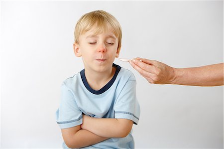 enfermedad - Parent trying to give son medicine, boy refusing Foto de stock - Sin royalties Premium, Código: 614-06168876