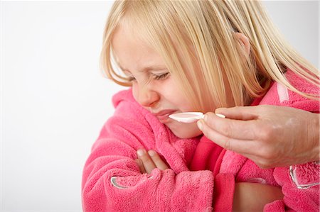 Parent trying to give daughter medicine, girl refusing Foto de stock - Sin royalties Premium, Código: 614-06168870