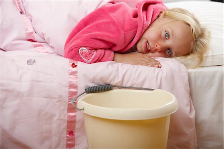 Ill girl in bed with bucket Stock Photo - Premium Royalty-Free, Code: 614-06168894