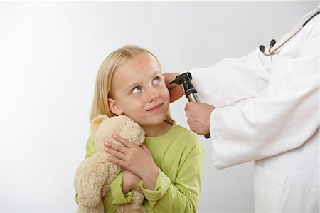 Doctor examining girl's ear Stock Photo - Premium Royalty-Free, Code: 614-06168890