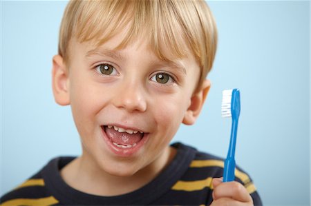 portrait boy studio smile - Boy holding toothbrush Stock Photo - Premium Royalty-Free, Code: 614-06168911