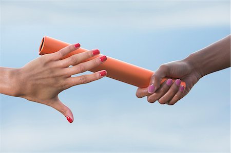 Hands of female relay athletes passing a baton, close up Foto de stock - Sin royalties Premium, Código: 614-06168943