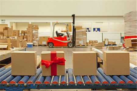 Cardboard box with red bow on conveyor belt Stock Photo - Premium Royalty-Free, Code: 614-06169110