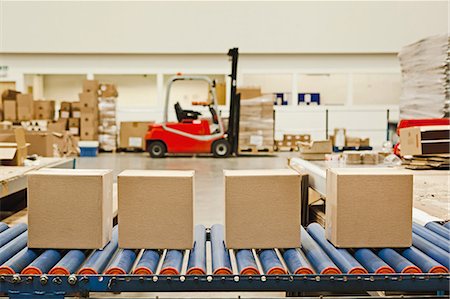 empilhadeira - Four cardboard boxes on conveyor belt Foto de stock - Royalty Free Premium, Número: 614-06169124