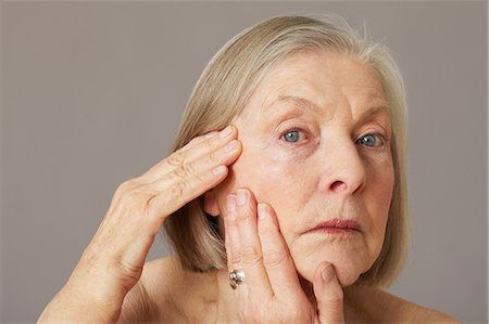 Senior woman touching face Stock Photo - Premium Royalty-Free, Code: 614-06169240