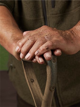 dirt - Man leaning with hands on wooden handle Stock Photo - Premium Royalty-Free, Code: 614-06169326