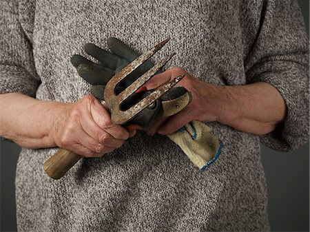 senior women gardening - Woman holding gardening glove and trowel Stock Photo - Premium Royalty-Free, Code: 614-06169320