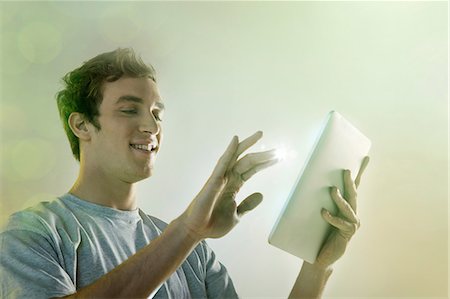 Young man using digital tablet with lights Stock Photo - Premium Royalty-Free, Code: 614-06169336