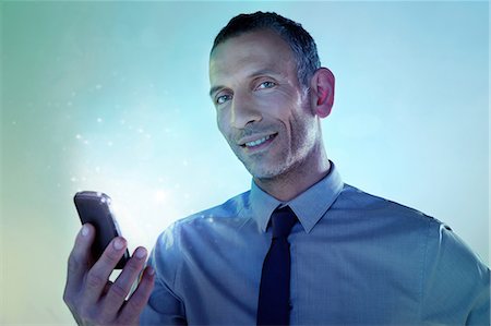 simsearch:614-06442504,k - Businessman holding cellphone with lights Foto de stock - Sin royalties Premium, Código: 614-06169339