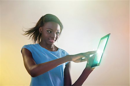 studio shot - Teenage girl touching digital tablet with lights Stock Photo - Premium Royalty-Free, Code: 614-06169345