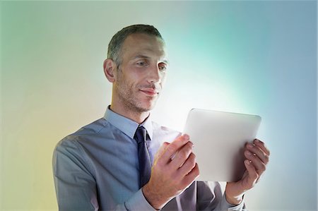 people tablet digital light - Businessman using digital tablet with lights Stock Photo - Premium Royalty-Free, Code: 614-06169342