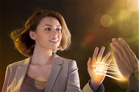 fiber optic cable - Young woman touching light streams, connecting to another person Stock Photo - Premium Royalty-Free, Code: 614-06169437