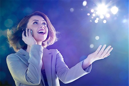 future of light - Young woman on cellphone, looking up at lights Stock Photo - Premium Royalty-Free, Code: 614-06169433