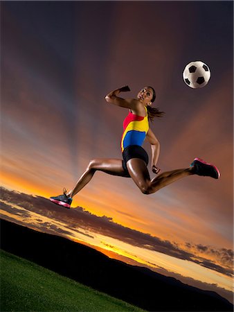 simsearch:614-06169453,k - Female footballer in mid air against sunset Stock Photo - Premium Royalty-Free, Code: 614-06169452