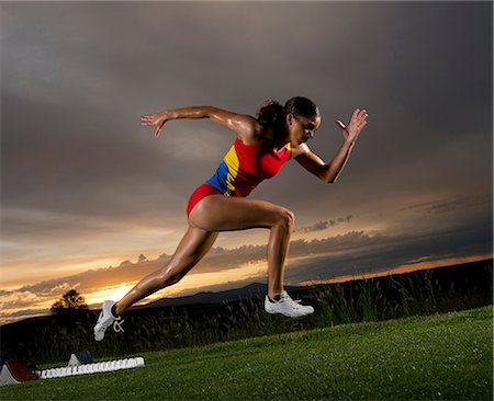 sprinter concentration - Female athlete leaving starting blocks Stock Photo - Premium Royalty-Free, Code: 614-06169464