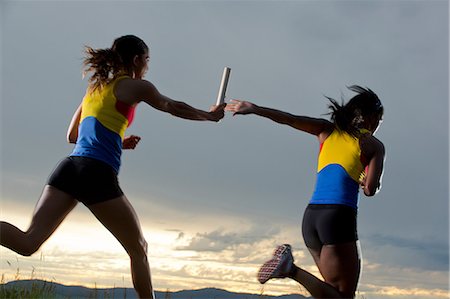 Female relay racers passing baton Foto de stock - Sin royalties Premium, Código: 614-06169460