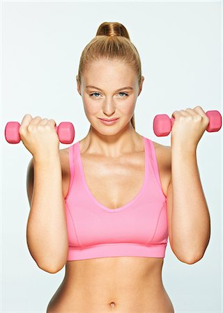 female fitness studio shot - Young woman using hand weights Stock Photo - Premium Royalty-Free, Code: 614-06169484