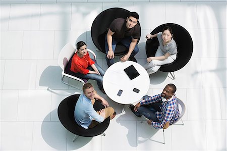 seated high view - Overhead view of colleagues in meeting, looking up at camera Stock Photo - Premium Royalty-Free, Code: 614-06169543