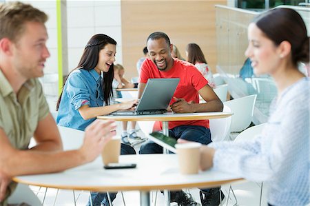 female sitting waiting room - Young couple in canteen area, looking at laptop Stock Photo - Premium Royalty-Free, Code: 614-06169584