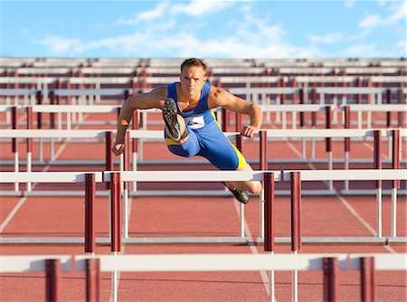 Male hurdler clearing hurdles Foto de stock - Sin royalties Premium, Código: 614-06311628