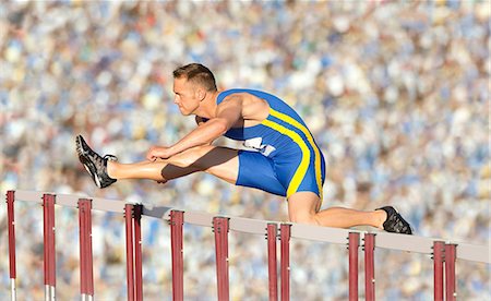 Male hurdler cleaning hurdle Foto de stock - Sin royalties Premium, Código: 614-06311634