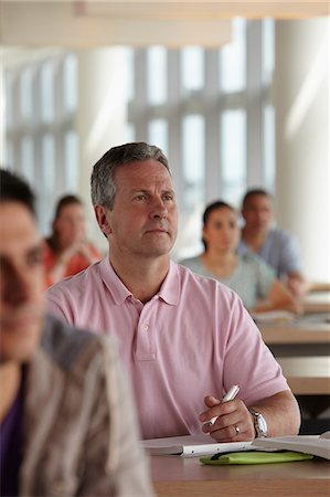 pondering in a university classroom - Mature students in class, man making notes Stock Photo - Premium Royalty-Free, Code: 614-06311674