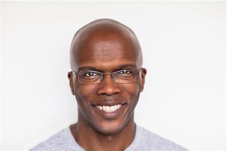 portrait bald men with glasses - Portrait of a bald man smiling Stock Photo - Premium Royalty-Free, Code: 614-06311747