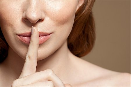 secreto - Woman with finger on lips, close up Foto de stock - Sin royalties Premium, Código: 614-06311811