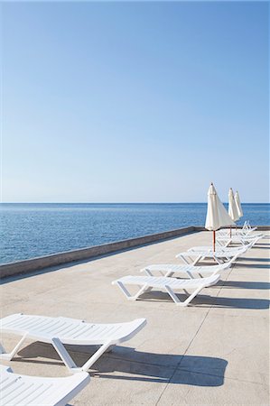 quitasol - Sun loungers on deck by the ocean Foto de stock - Sin royalties Premium, Código: 614-06311882