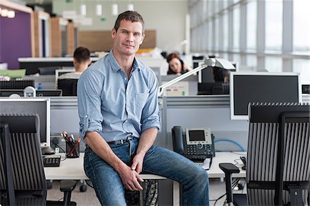 simsearch:614-06311928,k - Portrait of man sitting on desk Fotografie stock - Premium Royalty-Free, Codice: 614-06311929