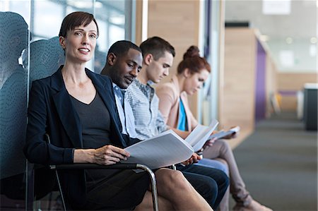 Four people sitting on chairs with documents Stock Photo - Premium Royalty-Free, Code: 614-06311960