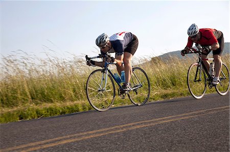 people on racing bikes - Two cyclists or road, racing downhill Stock Photo - Premium Royalty-Free, Code: 614-06311977