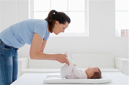 Mother with baby girl on changing mat Stock Photo - Premium Royalty-Free, Code: 614-06312001