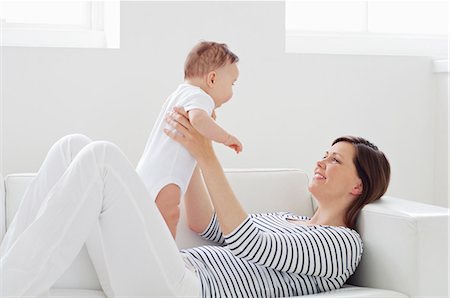 smiling baby pictures - Woman on sofa with baby daughter Stock Photo - Premium Royalty-Free, Code: 614-06312014