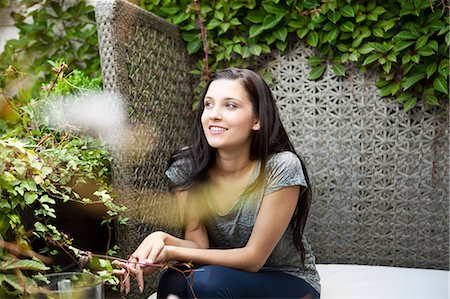 simsearch:614-06335976,k - Young woman sitting on bench in garden Foto de stock - Sin royalties Premium, Código: 614-06335983