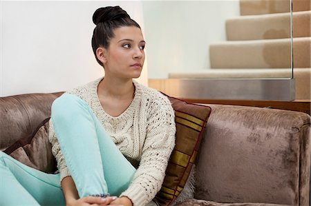 sad woman sitting alone on couch - Pensive young woman on sofa Stock Photo - Premium Royalty-Free, Code: 614-06336000