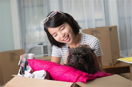 photos of asian people moving houses - Young woman with pet dog in moving box Stock Photo - Premium Royalty-Free, Code: 614-06336116